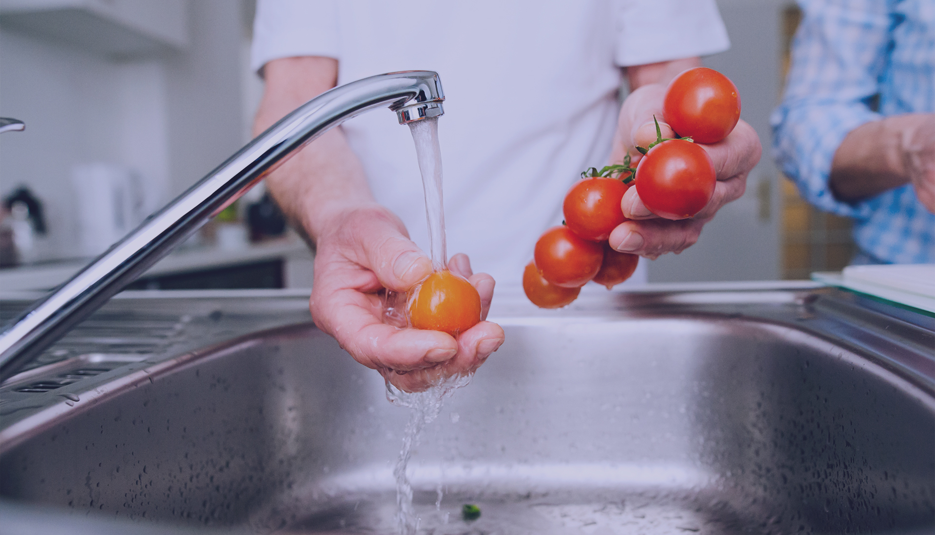man washing tomatos in sink